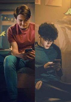 two men sitting on a couch looking at their cell phones and one is holding a phone