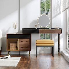 an empty room with a desk, mirror and chair next to a window in the corner