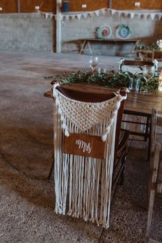 the table is set up with a macrame and greenery garland on it