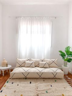 a living room filled with furniture and a large rug on top of a hard wood floor