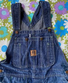 This listing is for a pair of the classic vintage 1980s Wrangler Big Ben blue denim overalls with orange tab labels and white stitching. These overalls are so great and are in good vintage condition! Overalls are a faded blue denim and have metal buttons on the side, metal snaps on the front bib, straps are adjustable and have metal hardware, there are also metal buttons in the button crotch. Overalls show just minor wear, nothing really to note! Overalls have orange Big Ben labels on the front Baggy Overalls Outfit 90s, Baggy Overalls Outfit, Overalls Outfit 90s, Baggy Overalls, Blue Denim Overalls, Hippie Grunge, Overalls Outfit, Outfit 90s, Personal Aesthetic