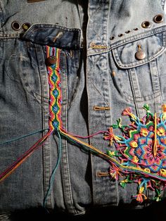 an old pair of jeans with colorful stitchs on them