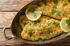 chicken with lemons and herbs in a pan