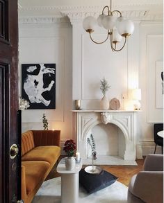 a living room filled with furniture and a fire place next to a doorway that leads to a sitting area