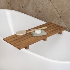 a bath tub with a wooden tray on it