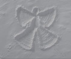 a snow angel drawn in the snow with its wings spread