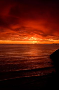 an orange and red sunset over the ocean