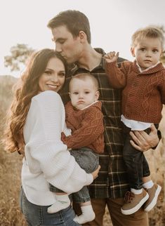 a man and woman holding two small children