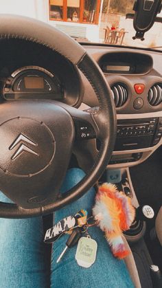 the interior of a car with a steering wheel, dashboard and keys hanging from it's center console