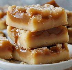 several pieces of dessert sitting on top of a white plate with caramel toppings