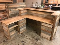 a wooden desk sitting inside of a room filled with lots of wood pallet boards