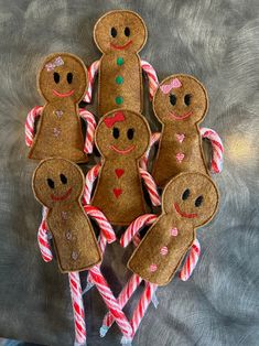 several gingerbread man and woman made out of candy canes on a gray background