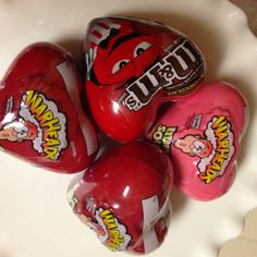 five red heart shaped candy candies on a white plate with the word utt