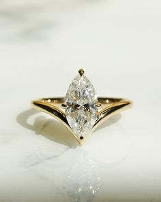 a yellow gold ring with a pear shaped diamond