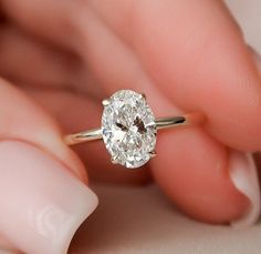 a close up of a person holding a ring with a diamond in it's center