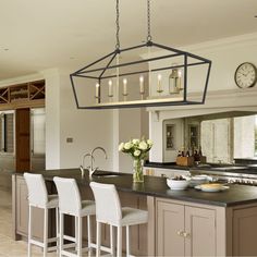 a kitchen with an island and bar stools in front of the countertop area