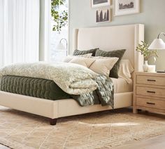 a bedroom with a bed, dressers and pictures hanging on the wall above it