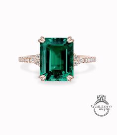 an emerald and diamond ring with diamonds around it