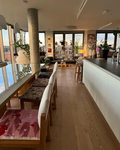 a long table and chairs in a room with large windows overlooking the city below it