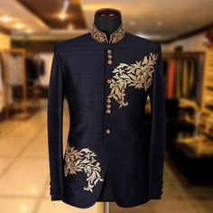 a blue jacket with gold embroidery on it in a store display case at the end of a hall