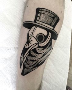 a man's arm with a black and white tattoo design on the left forearm