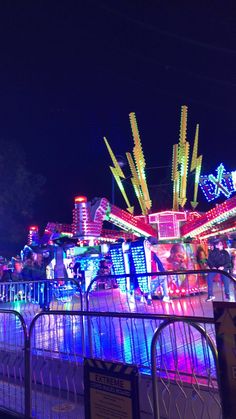 an amusement park lit up at night with lights