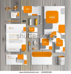 an orange and white stationery set on wooden background with clippings for text