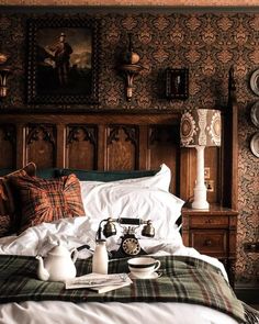 an old fashioned phone is sitting on a bed with plaid sheets and pillows in the room