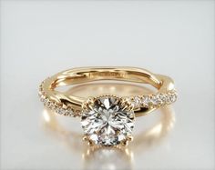 a yellow gold engagement ring with a round cut diamond in the center and side stones on each band