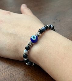 Our evil eye protection beaded bracelets are made with blue evil eye beads and a combination of black onyx and sodalite. Each bracelet is made with the intention to protect you from the evil eye and negative energies through each gemstone, and they're stretchy enough to fit a variety of wrist sizes. Please note that each bracelet is handcrafted for your order, so you will not receive the exact one pictured. ----------------------------------------------------------------------------------------- Black Spiritual Evil Eye Bracelet, Black Beaded Bracelet With Evil Eye, Spiritual Black Evil Eye Bracelet With 8mm Beads, Black Spiritual Evil Eye Bracelet With Round Beads, Spiritual Black Evil Eye Bracelet With Round Beads, Black Evil Eye Bracelet With Black Beads, Black Evil Eye Bracelet With Beads, Black Evil Eye Bracelet Spiritual Style, Adjustable Evil Eye Bracelet With Black Beads