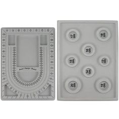 two plastic trays with buttons and numbers on the bottom one has a ruler in it