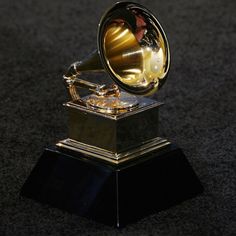 a gold and black trophy sitting on top of a black table next to a carpet