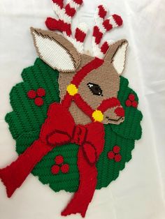 an embroidered deer with red bows on it's head