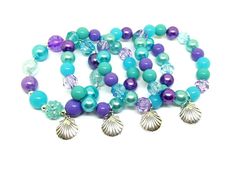 Charms will be smaller than those pictured. These adorable bracelets are the perfect favor for your little one's Under The Sea or Mermaid themed party! Each bracelet features a Tibetan silver charm and an assortment of purple, blue and cyan 10mm acrylic beads strung with durable stretch floss cord. Each bracelet will arrive individually packaged in organza bags. One special bracelet made with 12mm acrylic beads for the birthday girl. It is important that she feels special on her special day and Skate Birthday, Seashell Bracelet, Princess Party Favors, Girl Bracelet, Mermaid Theme Party, Cardboard Jewelry Boxes, Rainbow Bracelet, Chunky Jewelry, Name Bracelet