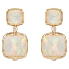 Sweet Sugarloaves! Light and easy to wear these earrings showcase beautiful sugarloaf gemstones accented with a gold frame and diamonds. These earrings are dainty yet have a great pop of color from the vibrant gems. Ethiopian Opal Sugarloaf Earrings with Diamond in 18 Karat Yellow Gold Ethiopian Opal: 2.95 carats, 8x8mm size, cushion sugarloaf cabochon, 2 pieces. Ethiopian Opal: 10.95 carats, 12x12mm size, cushion sugarloaf cabochon, 2 pieces. Diamond: 0.134 carats, round shape, G color VS clari Ethiopian Opal Earrings, Naha, Antique Earrings, Opal Earrings, Modern Earrings, Opal Jewelry, Pearl Drop Earrings, Modern Jewelry, Ethiopian Opal