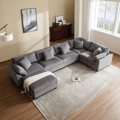 a large sectional couch sitting on top of a wooden floor next to a white rug