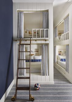 a room with bunk beds and ladders in the corner, next to a ball on the floor