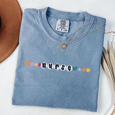 a blue tshirt with the word nurse on it next to a cowboy hat