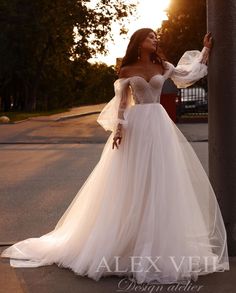 a woman in a wedding dress leaning against a pole