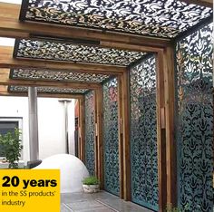 an outdoor room with decorative metal screens and wood trimming on the walls, in front of