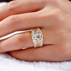 a woman's hand with two gold rings on it and one diamond ring in the middle