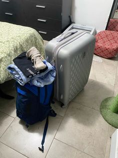 luggage sitting on the floor next to a bed