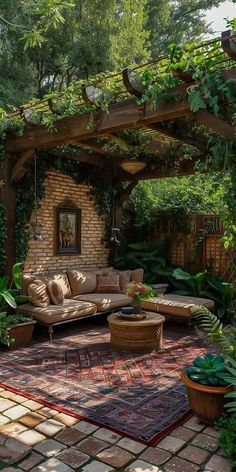 an outdoor living area with couches, tables and potted plants on the ground