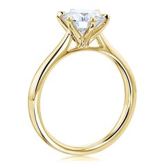 a yellow gold engagement ring with an oval cut diamond in the center, on a white background