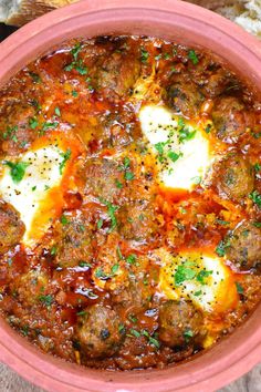 meatballs in tomato sauce with parsley on top and bread slices next to it