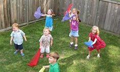 a group of children playing with kites in the yard