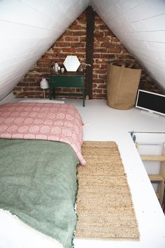 an attic bedroom with exposed brick walls and carpet