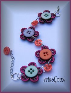 a bracelet with buttons and chains attached to it