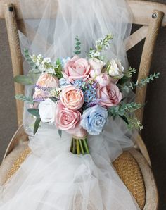 a bridal bouquet sitting on top of a wooden chair