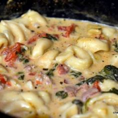 pasta with spinach and tomato sauce in a skillet